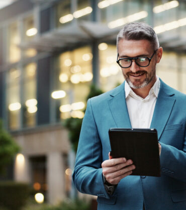 man smilling whil looking at his ipad
