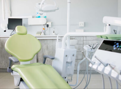 Empty dentist room, chair and equipment for cleaning, wellness and oral health with tools in clinic. Hospital, dental and mouth care by furniture, machine or interior for teeth, surgery or consulting
