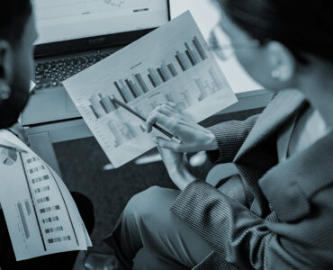 two people discussing over number and graphics