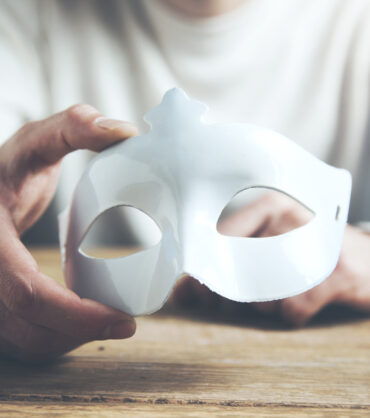 Man hand mask on wooden table background