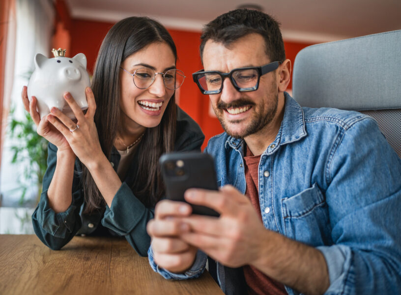 couple take a self portrait or video call while hold piggy bank at home Saving money