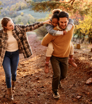 Family with small child hiking outdoors in autumn nature