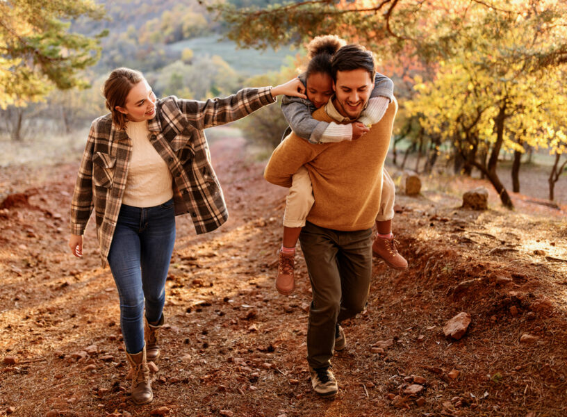Family with small child hiking outdoors in autumn nature